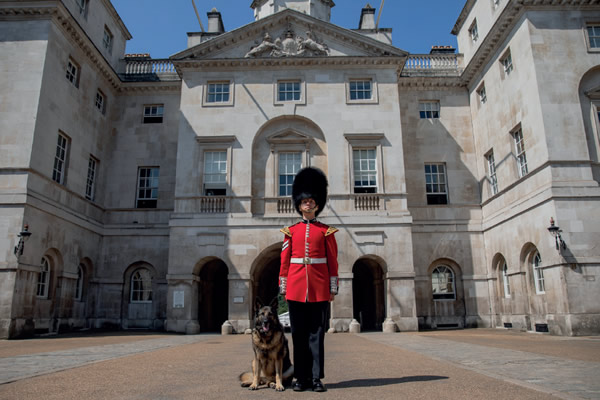 RPD Tilly sitting next to a Guardsmen in traditional red jacket and bearskin hat (busbies) at Horse Guards Parade
